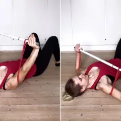 Kvinna utför latsdrag med gummiband liggandes på golvet.