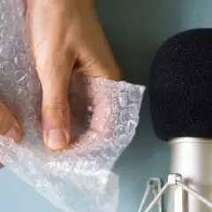 Händer som försiktigt knäpper bubbelplast nära en mikrofon, skapar härliga asmr ljud.
