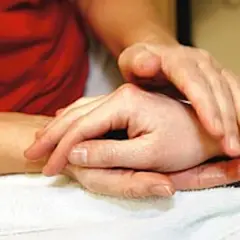 Händer som utför taktil massage på en arm. En varm och lugnande beröring.