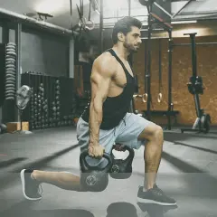 Man utför utfall med kettlebells under ett intensivt crossfit pass i ett modernt gym.
