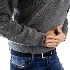 En vuxen person med magsmärtor, som kan vara relaterade till gul diarré.
