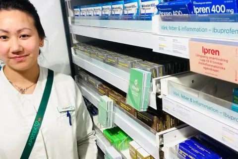 En farmaceutstudent vid en apotekshylla med smärtlindrande mediciner. Frågor om naproxen 500 mg hur ofta kan besvaras här.