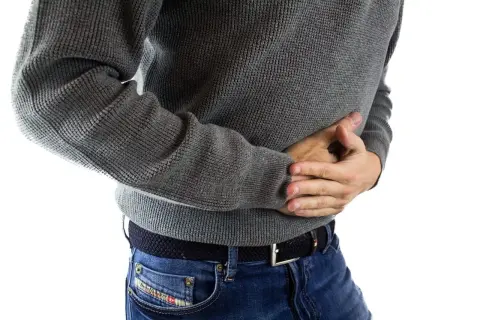 En vuxen person med magsmärtor, som kan vara relaterade till gul diarré.
