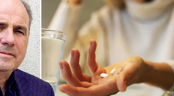 En man med bekymrat ansikte bredvid en hand som håller tabletter, kanske för att lindra migrän. Naproxen mot migrän kan vara en lösning.