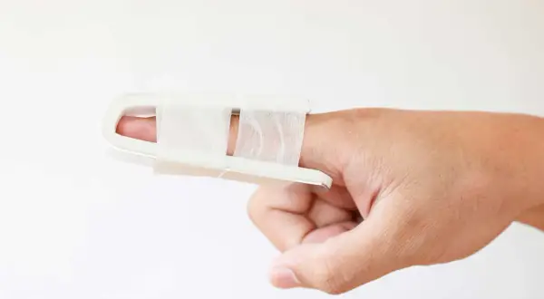 Stukat finger tejpat med en vit skena för stöd.