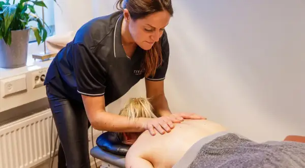 En massör utför ryggmassage, en av många olika typer av massage som erbjuds för avslappning och välbefinnande.