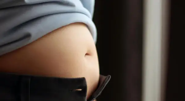 En svullen mage kan vara ett tecken på klimakteriet, där kroppens hormoner förändras och kan påverka fettfördelningen.
