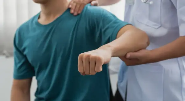 Läkare undersöker en patient med misstänkt armbåge ur led.