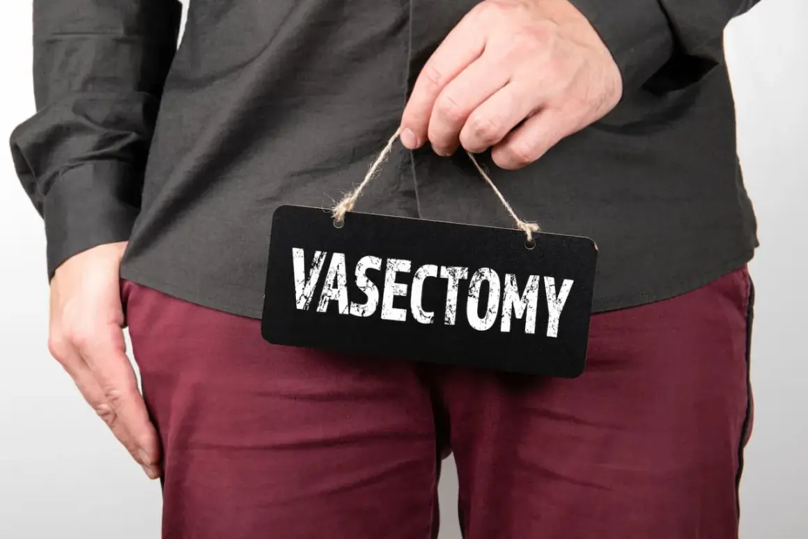 A person holds a black sign with "VASECTOMY" written in white text.