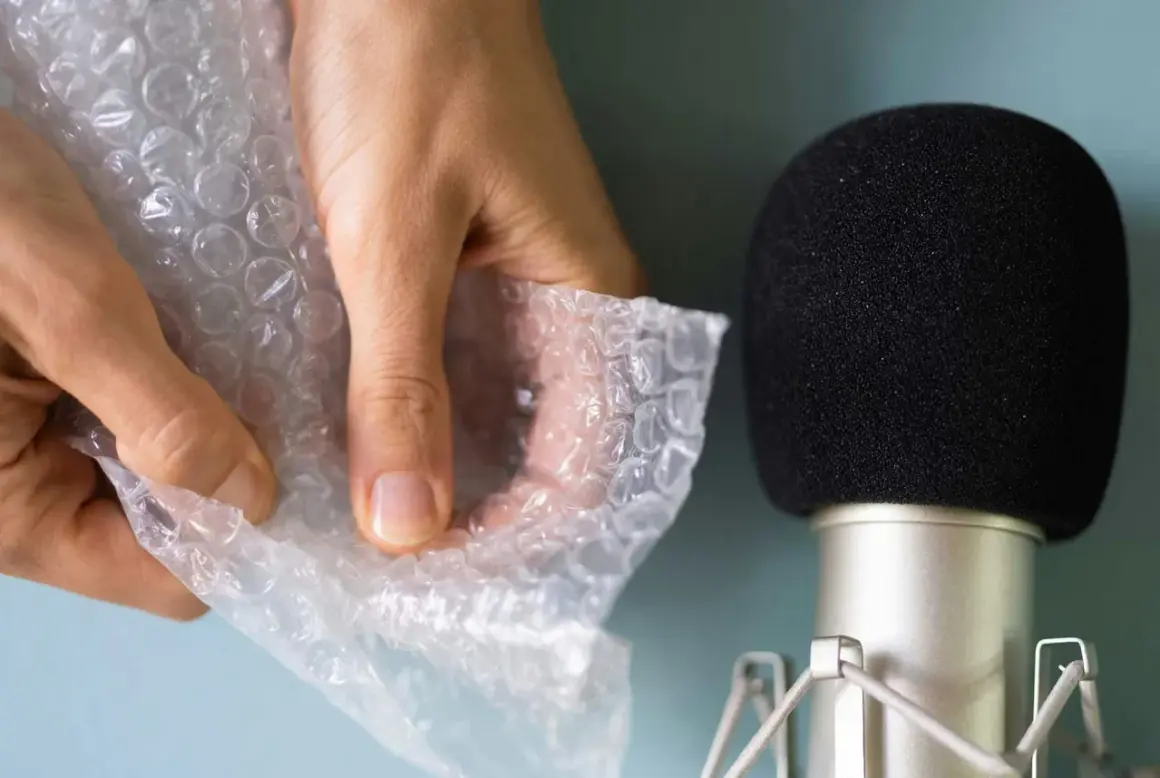Händer som försiktigt knäpper bubbelplast nära en mikrofon, skapar härliga asmr ljud.