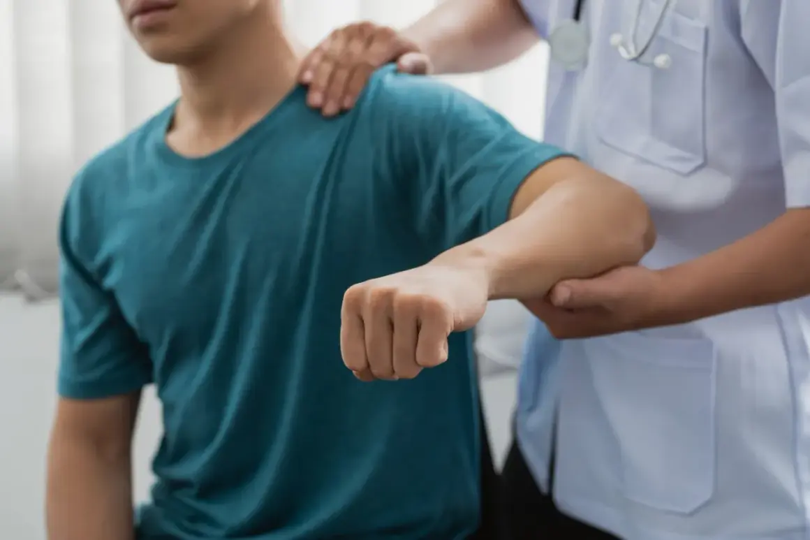 Läkare undersöker en patient med misstänkt armbåge ur led.