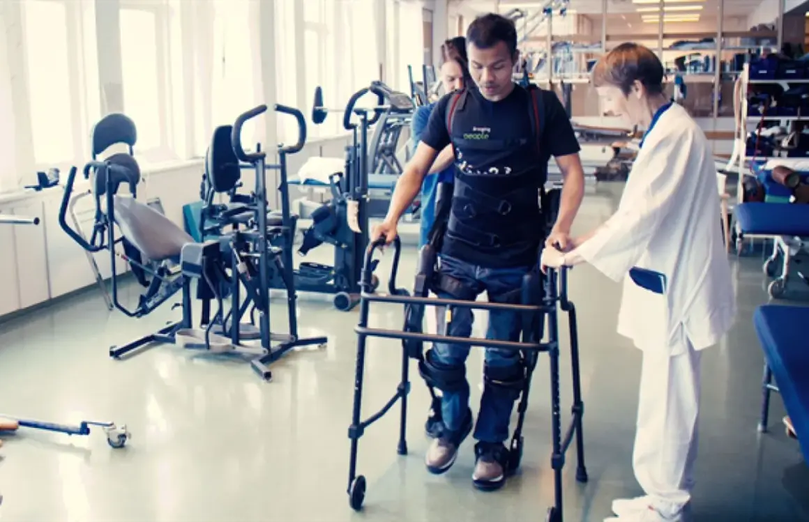Man med gånghjälpmedel och stöd av terapeut, rehabiliterar efter neglekt stroke.