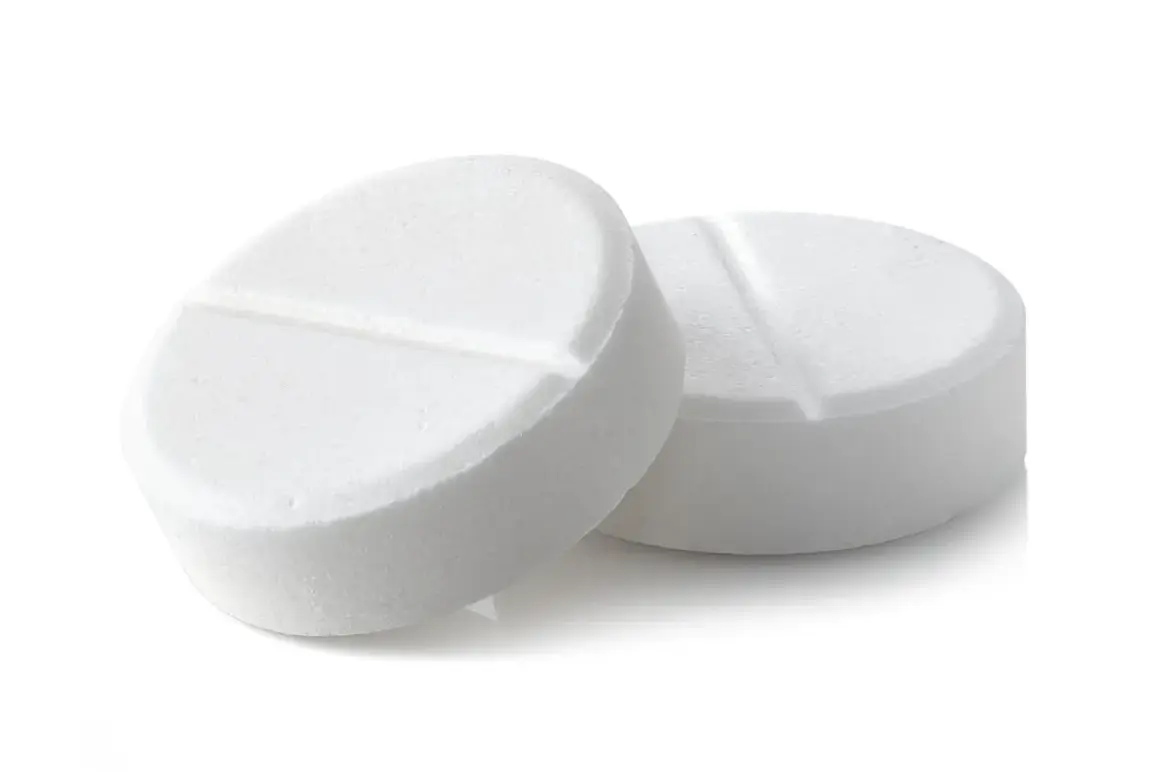 Two white, round pills with a score line down the middle, on a white background.
