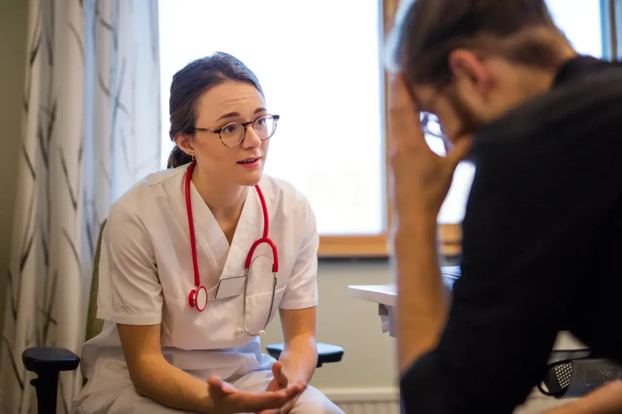 Läkare diskuterar fatigue och medicin med patient.