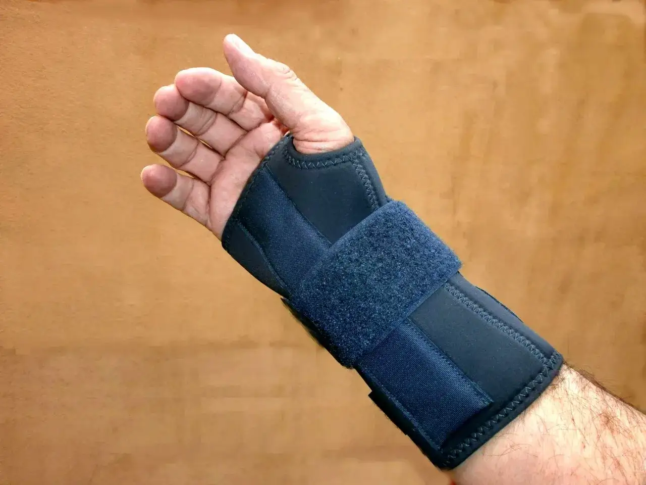 Hand med handledsskydd f&ouml;r en stukad tumme.