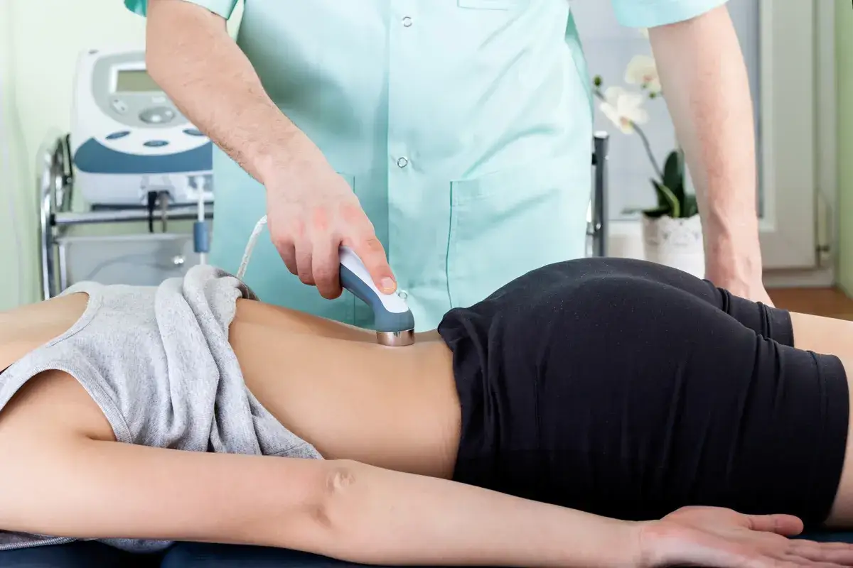 Fysioterapeut använder laser för behandling av ryggsmärta. Laser användningsområden inkluderar smärtlindring och rehabilitering.