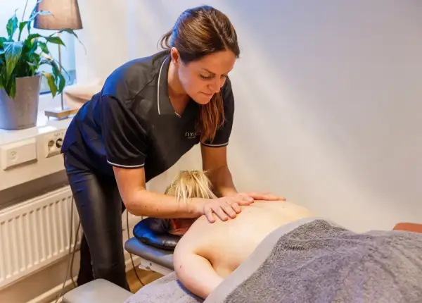 En massör utför ryggmassage, en av många olika typer av massage som erbjuds för avslappning och välbefinnande.