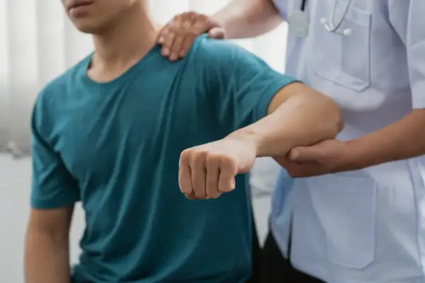 Läkare undersöker en patient med misstänkt armbåge ur led.