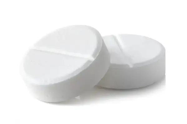 Two white, round pills with a score line down the middle, on a white background.